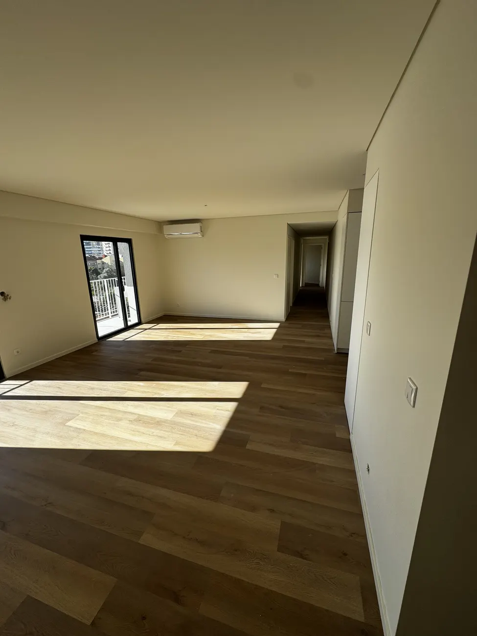 Sala do apartamento T1 com pavimento vinílico SPC e luz natural